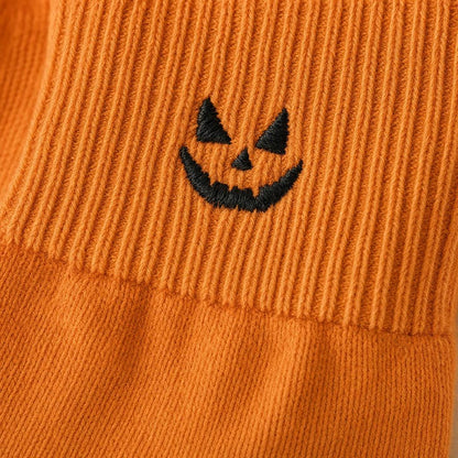 Macro of the embroidered pumpkin and ribbed cuff seam